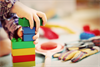 Symboldbild für Kindergarten - Bild zeigt Kinderhände, die gerade mit Lego spielen